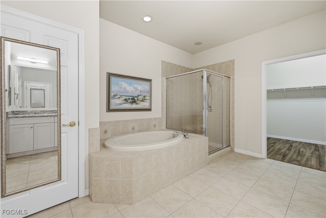 14951 Reflection Key Circle, Unit 536 Fort Myers, FL 33907 - Photo 15 of 36 a bathroom with a tub a sink and mirror