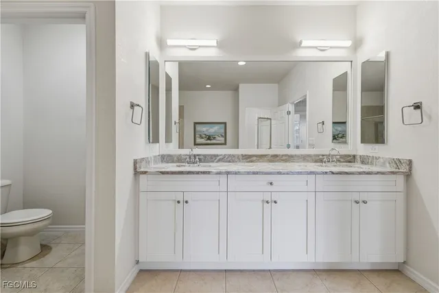 a bathroom with a granite countertop sink a toilet and a mirror
