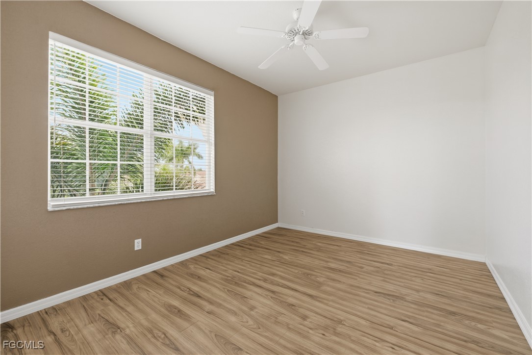 14951 Reflection Key Circle, Unit 536 Fort Myers, FL 33907 - Photo 19 of 36 a view of an empty room with wooden floor and a window