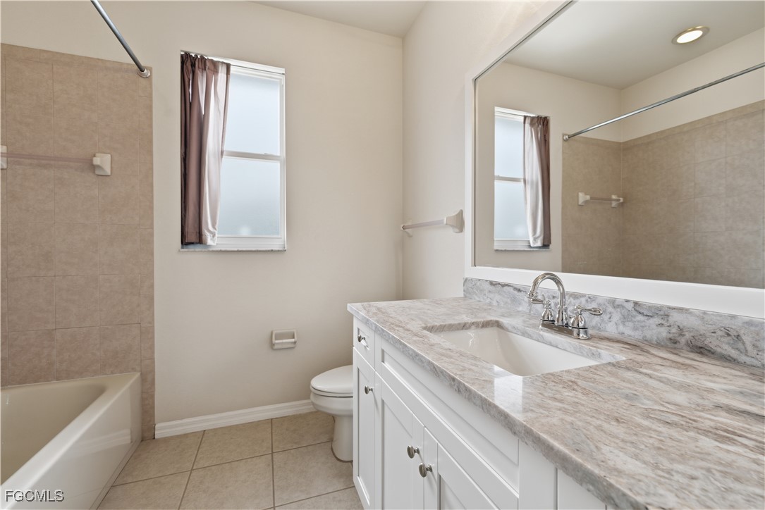 14951 Reflection Key Circle, Unit 536 Fort Myers, FL 33907 - Photo 20 of 36 a bathroom with a granite countertop sink a toilet and bathtub