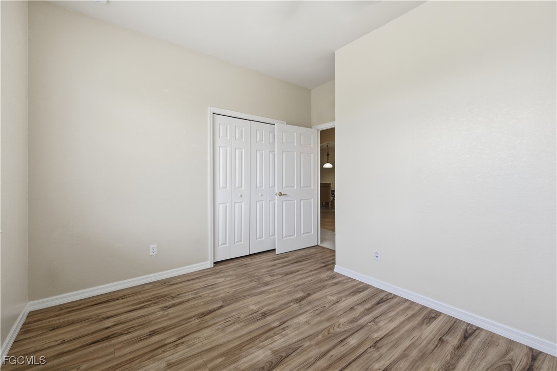 14951 Reflection Key Circle, Unit 536 Fort Myers, FL 33907 - Photo 22 of 36 a view of an empty room with wooden floor