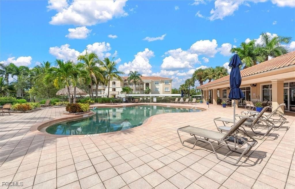 14951 Reflection Key Circle, Unit 536 Fort Myers, FL 33907 - Photo 29 of 36 a swimming pool with outdoor seating and yard