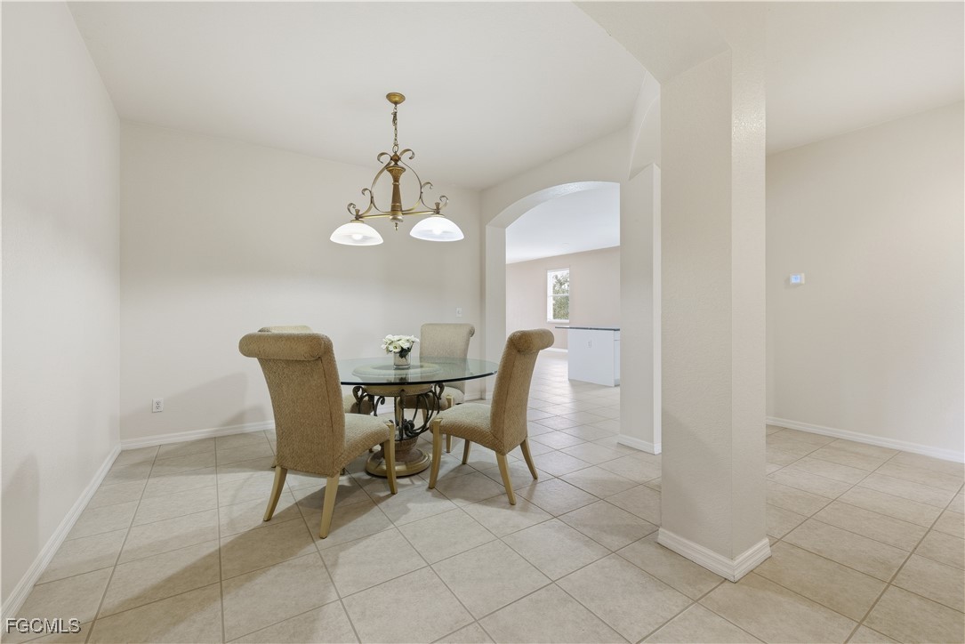 14951 Reflection Key Circle, Unit 536 Fort Myers, FL 33907 - Photo 3 of 36 a view of a dining room with furniture and chandelier
