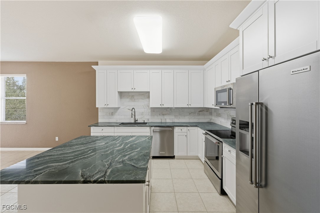 14951 Reflection Key Circle, Unit 536 Fort Myers, FL 33907 - Photo 6 of 36 a kitchen with stainless steel appliances granite countertop a sink stove and refrigerator