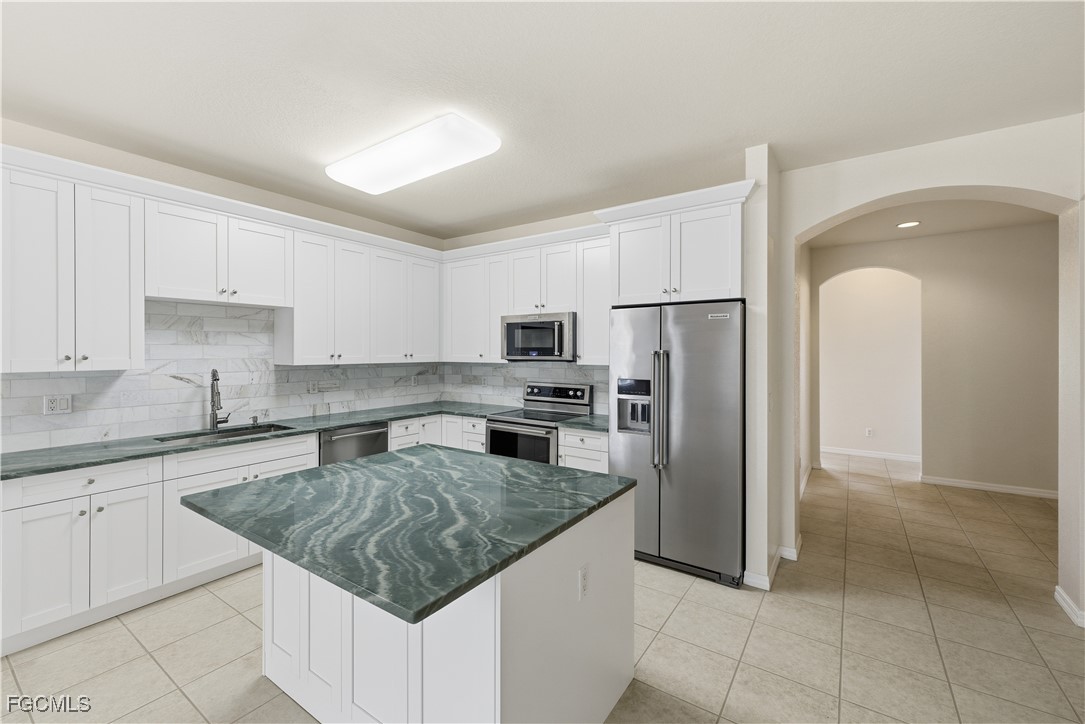 14951 Reflection Key Circle, Unit 536 Fort Myers, FL 33907 - Photo 8 of 36 a kitchen with stainless steel appliances granite countertop a refrigerator sink and cabinets