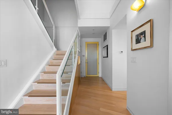 a view of a hallway with wooden floor and entryway