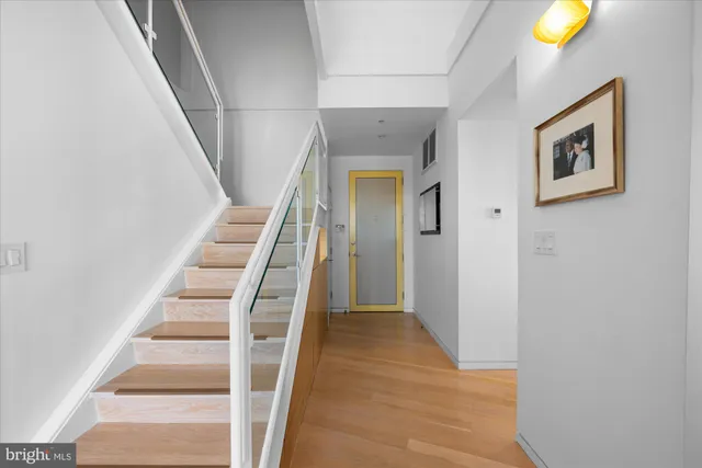 a view of a hallway with wooden floor and entryway
