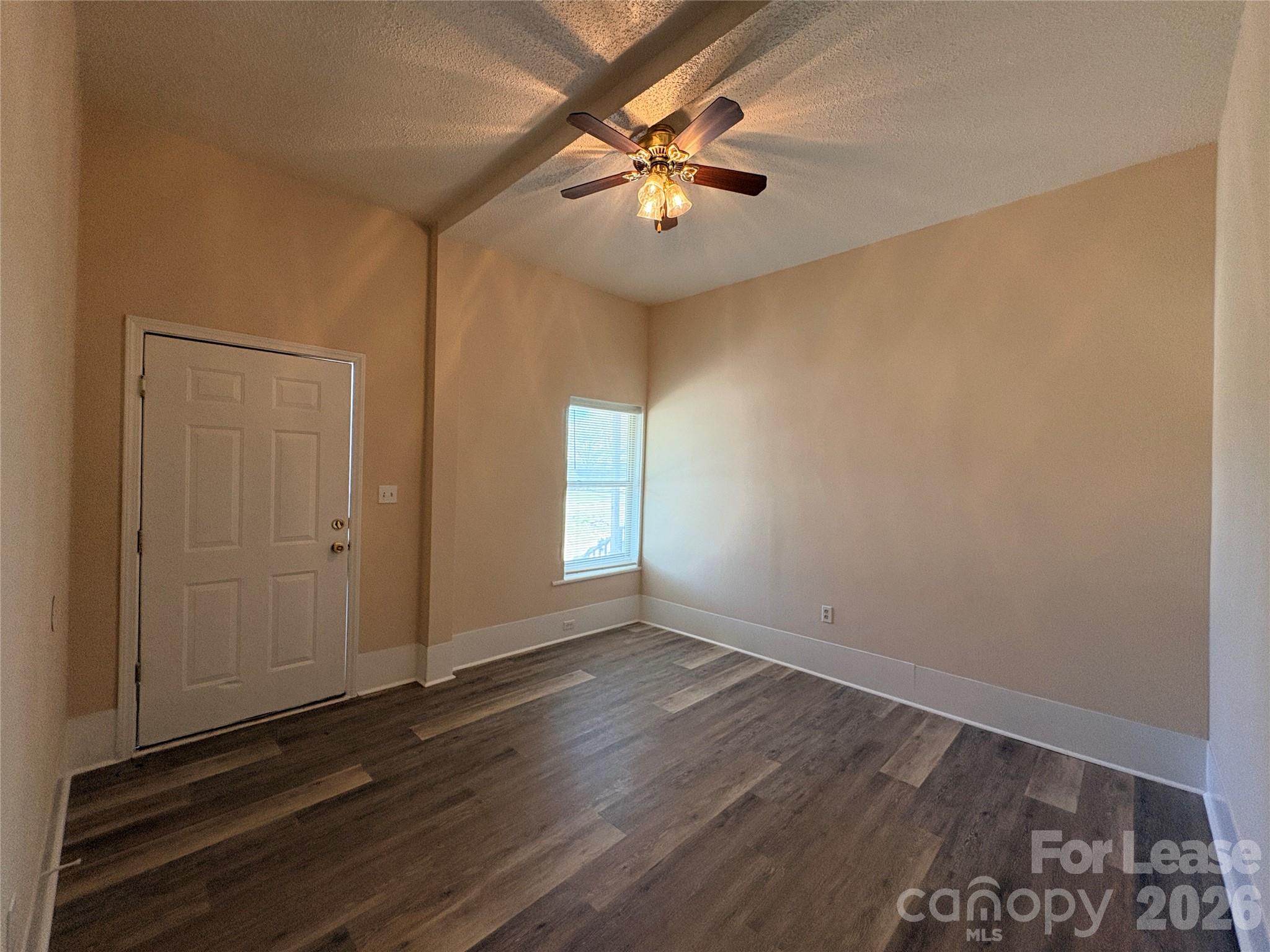 1109 6th Street, Unit B Lancaster, SC 29720 - Photo 3 of 22 an empty room with wooden floor fan and windows