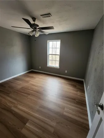 a view of empty room with window and ceiling fan