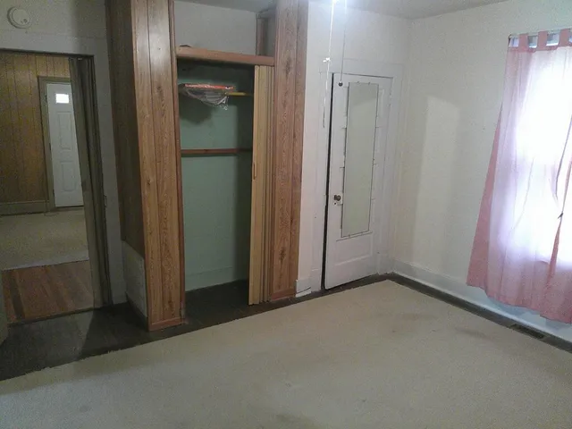 an empty room with windows and closet