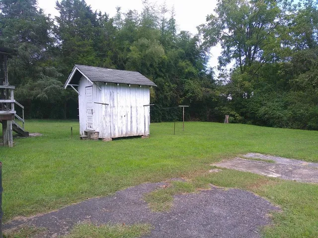 a view of backyard with barn and large trees