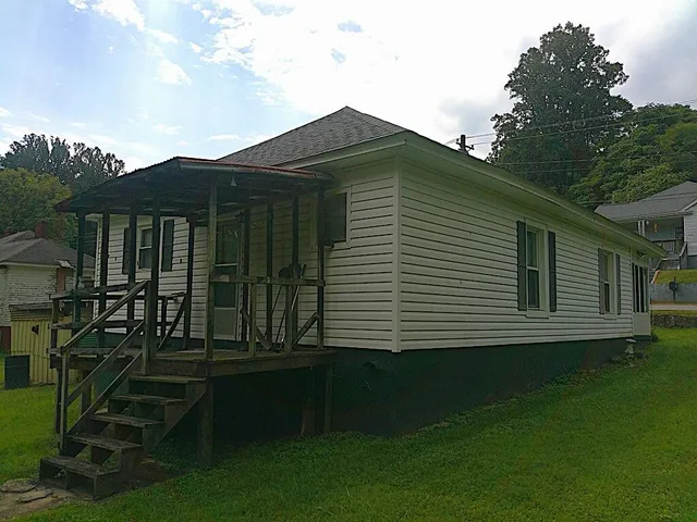 a view of backyard with barbeque grill and wooden fence