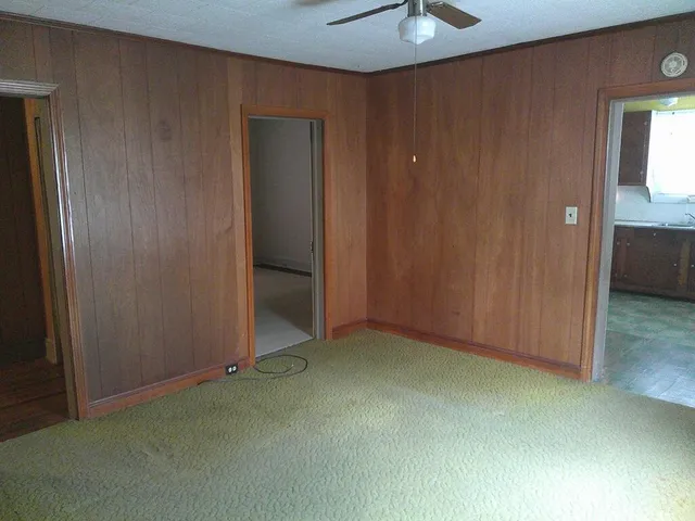 an empty room with a ceiling fan and closet area