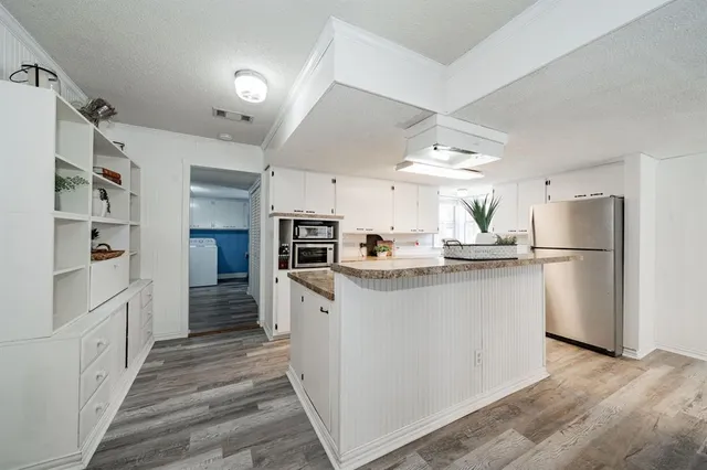 a kitchen with white cabinets and stainless steel appliances