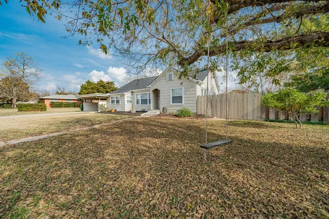 a backyard of a house with table and chairs