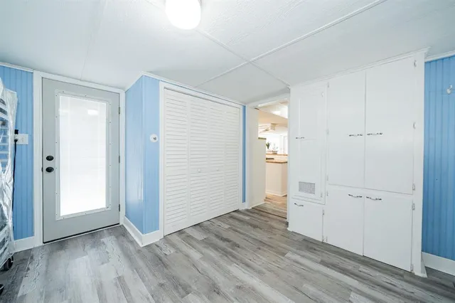 an empty room with wooden floor & closet and windows