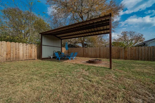 a backyard of a house with a table and chairs