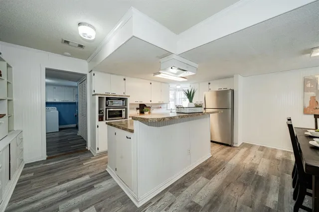 a kitchen with white cabinets and stainless steel appliances