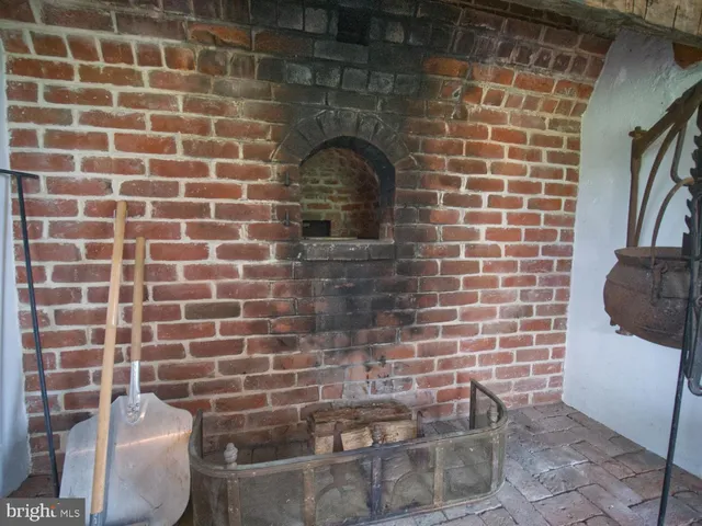 a view of a backyard with table and chairs potted plants and a large tree