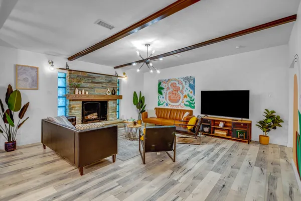 a living room with furniture a flat screen tv and a fireplace
