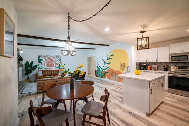 a view of a dining room with furniture a chandelier and wooden floor