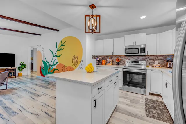 a kitchen with stainless steel appliances a stove a sink and a refrigerator