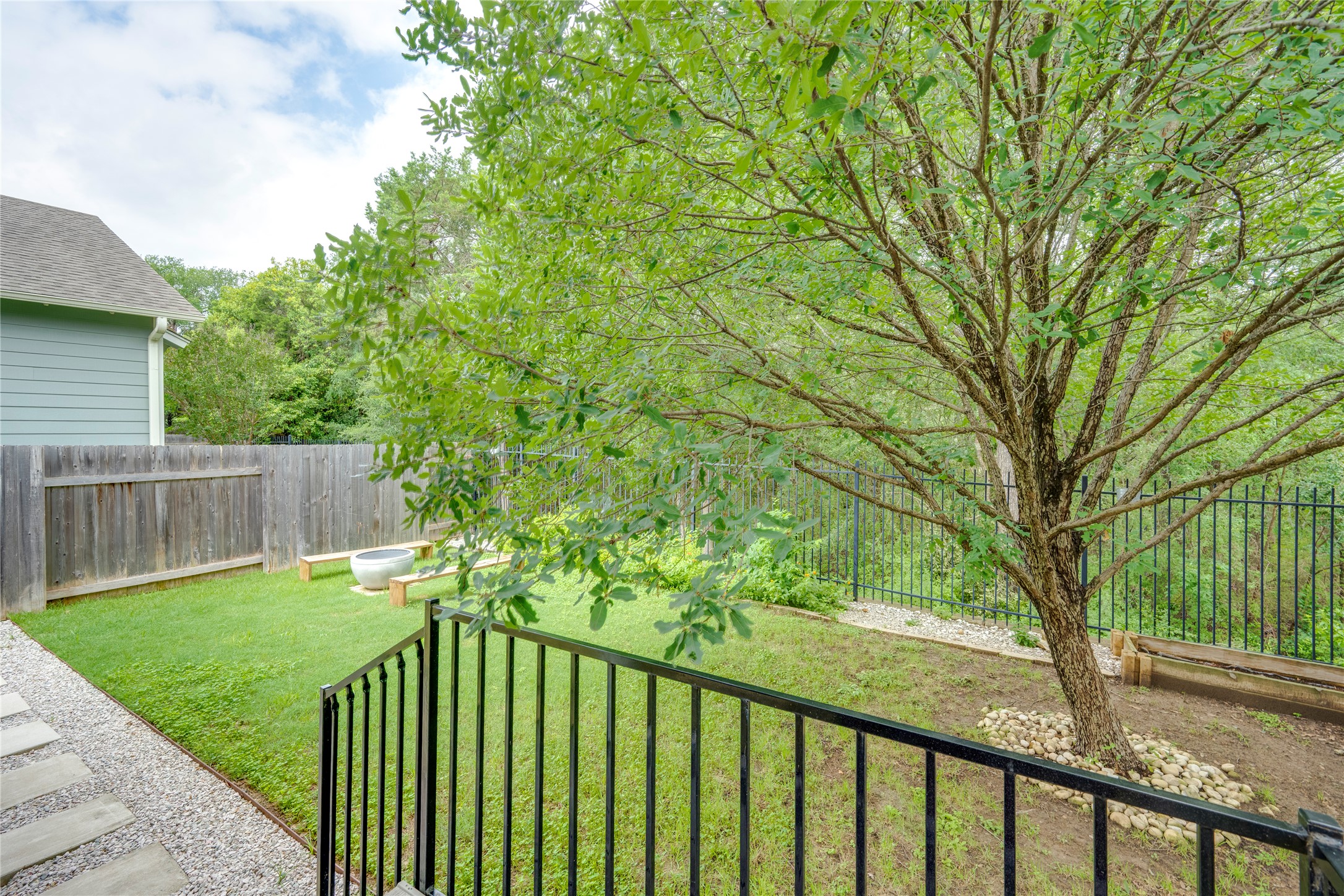 6008 Whipple Way Austin, TX 78745 - Photo 29 of 39 A verdant backyard with a lush tree and a charming fire pit, perfect for outdoor gatherings.