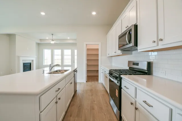 a kitchen with sink a microwave and cabinets
