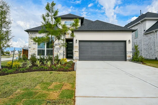a front view of yellow house with a yard