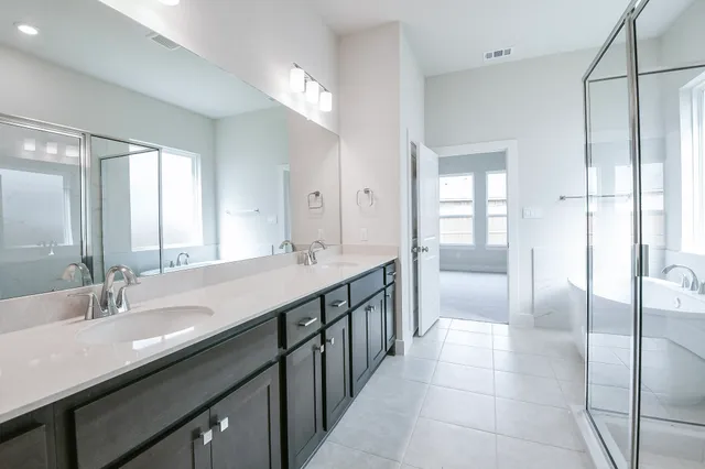 a spacious bathroom with a tub sink shower and mirror