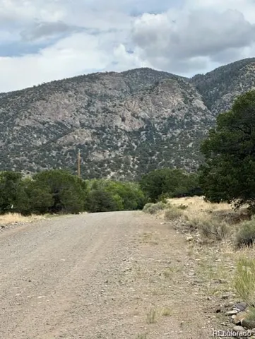 a view of a dry yard covered with snow in the background