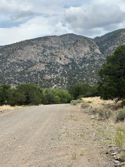 110 Indian Hill Road Mosca, CO 81146 - Photo 4 of 7 a view of a dry yard covered with snow in the background
