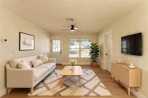 a living room with furniture a flat screen tv and a large window