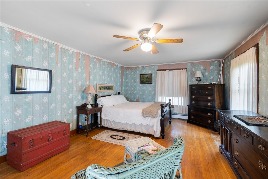 4007 Ridge Road Williamson, NY 14589 - Photo 23 of 34 The HUGE primary bedroom- well maintained hardwoods too!