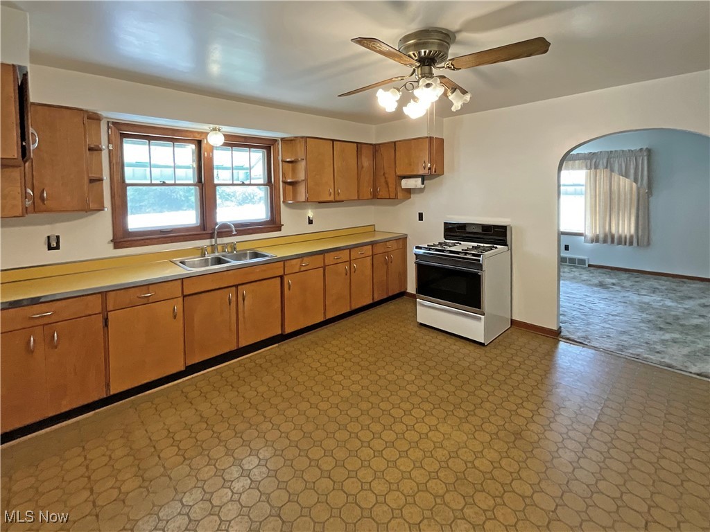63 Mc Coll Road Colliers, WV 26035 - Photo 4 of 17 Kitchen featuring white range with gas cooktop, sink, ceiling fan, and light tile patterned floors