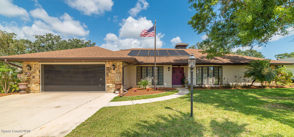 1401 Meadowbrook Road Northeast Palm Bay, FL 32905 - Photo 1 of 46 a patio with a table and chairs under an umbrella