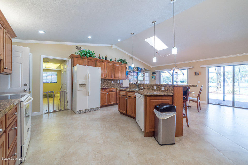 1401 Meadowbrook Road Northeast Palm Bay, FL 32905 - Photo 19 of 46 a kitchen with a refrigerator and a stove top oven