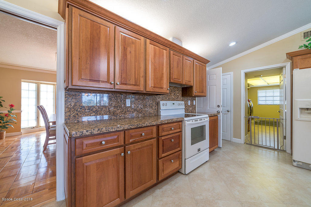 1401 Meadowbrook Road Northeast Palm Bay, FL 32905 - Photo 20 of 46 a kitchen with stainless steel appliances granite countertop a stove and a sink