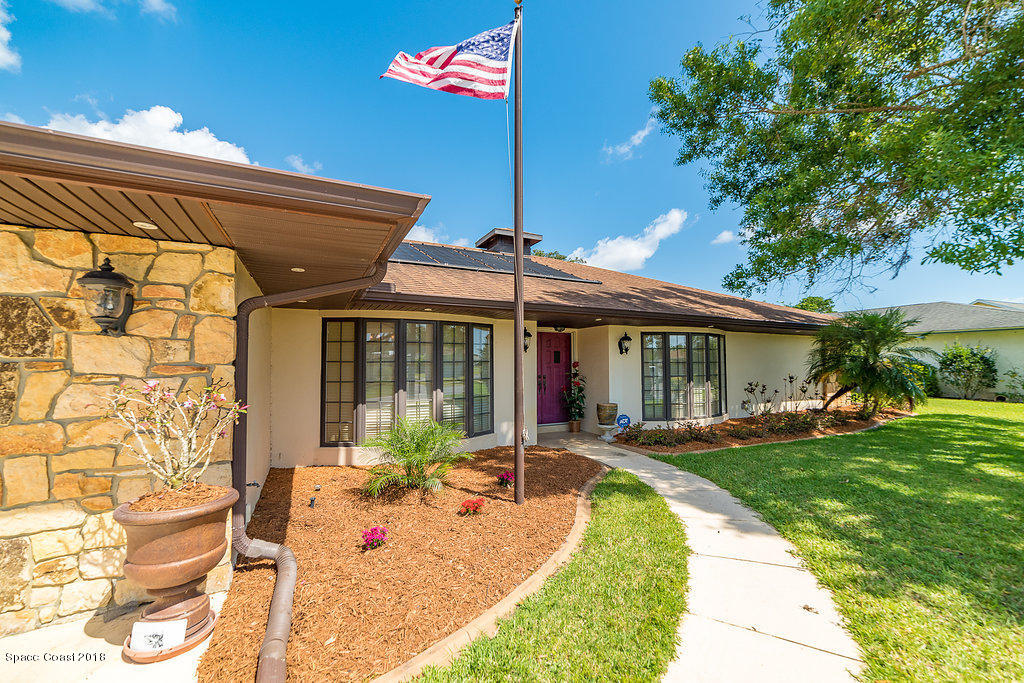 1401 Meadowbrook Road Northeast Palm Bay, FL 32905 - Photo 3 of 46 a view of a house with a yard patio and a fire pit