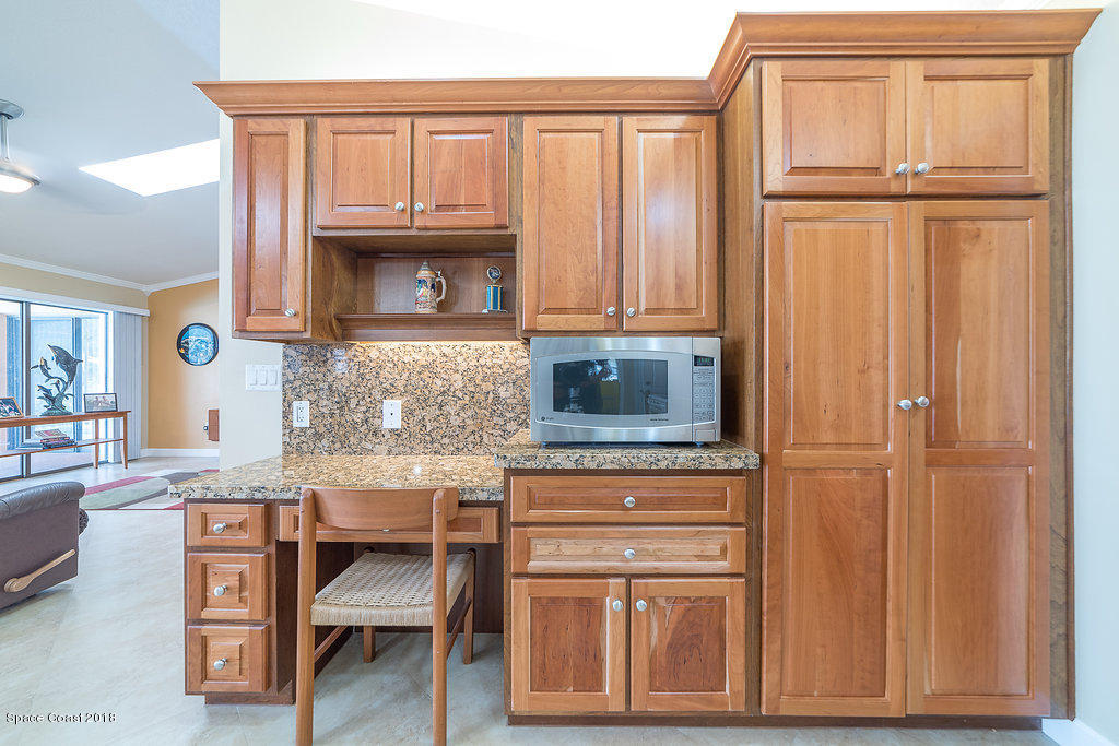1401 Meadowbrook Road Northeast Palm Bay, FL 32905 - Photo 21 of 46 a kitchen with granite countertop wooden cabinets and a stove top oven
