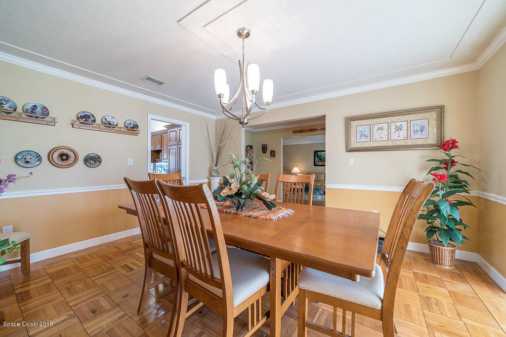 1401 Meadowbrook Road Northeast Palm Bay, FL 32905 - Photo 25 of 46 a view of a dining room with furniture and chandelier