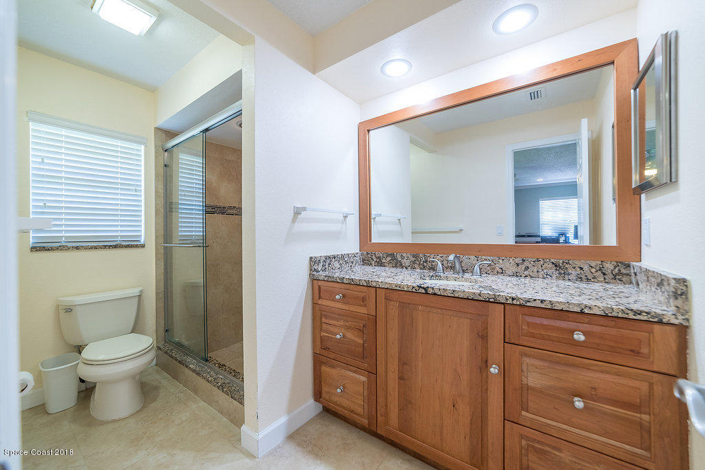1401 Meadowbrook Road Northeast Palm Bay, FL 32905 - Photo 30 of 46 a bathroom with a granite countertop toilet sink and a mirror