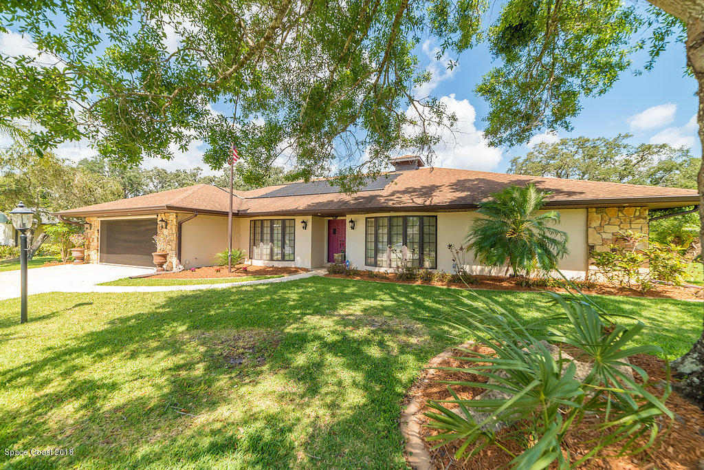 1401 Meadowbrook Road Northeast Palm Bay, FL 32905 - Photo 4 of 46 a front view of a house with a garden