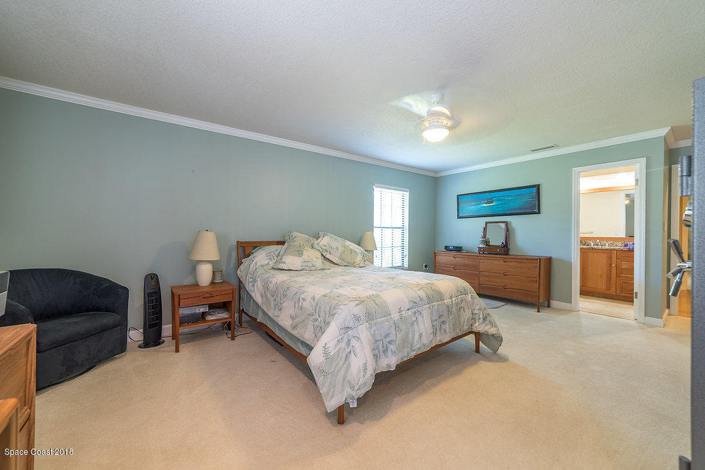 1401 Meadowbrook Road Northeast Palm Bay, FL 32905 - Photo 31 of 46 a bed room with a bed and a chair