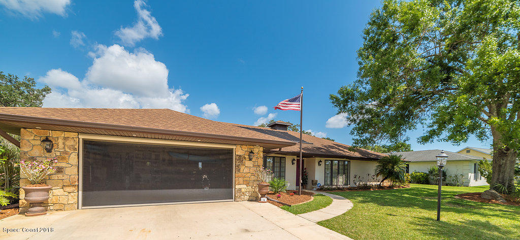 1401 Meadowbrook Road Northeast Palm Bay, FL 32905 - Photo 5 of 46 a front view of a house with a yard and garage