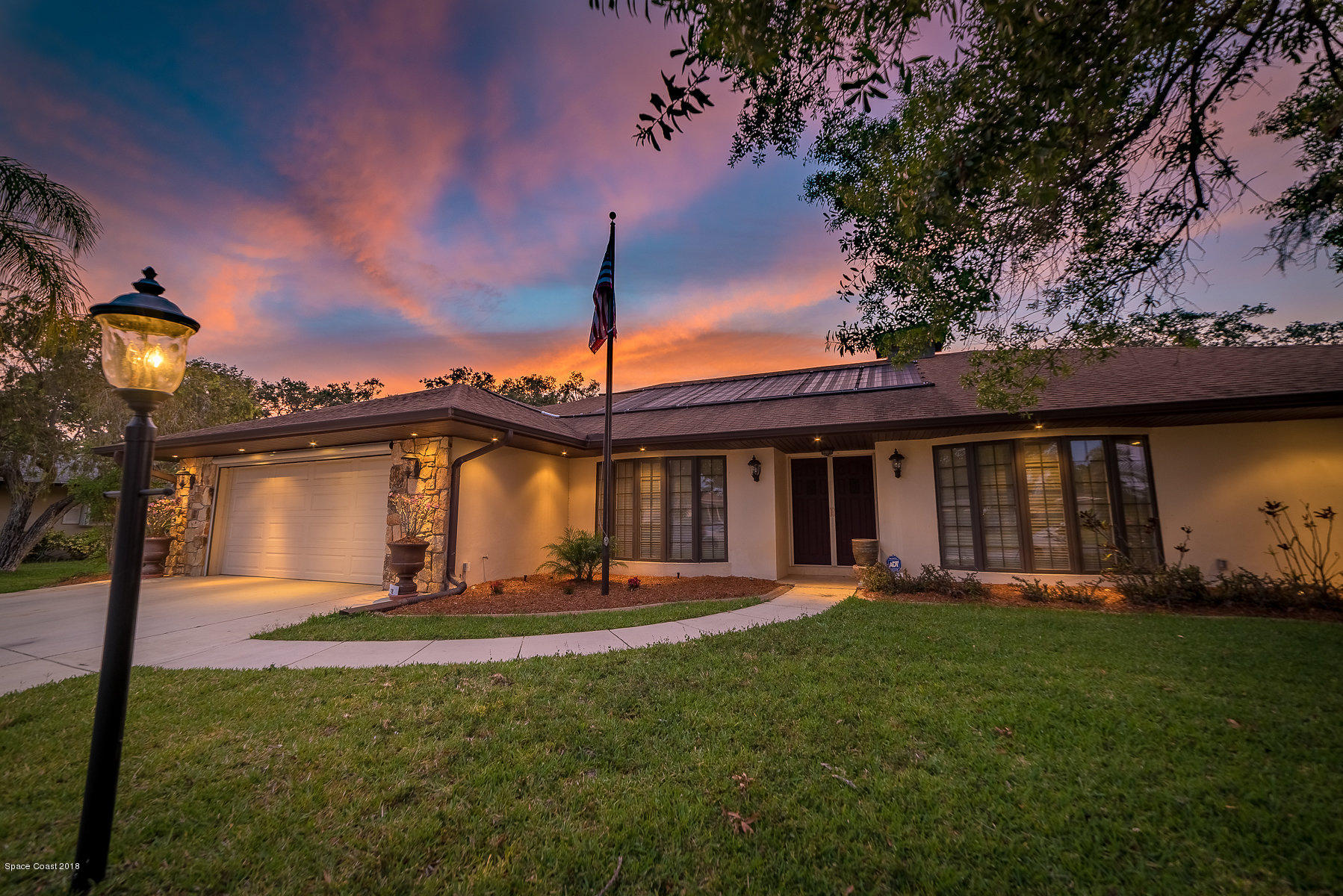 1401 Meadowbrook Road Northeast Palm Bay, FL 32905 - Photo 45 of 46 a front view of a house with a yard and palm trees