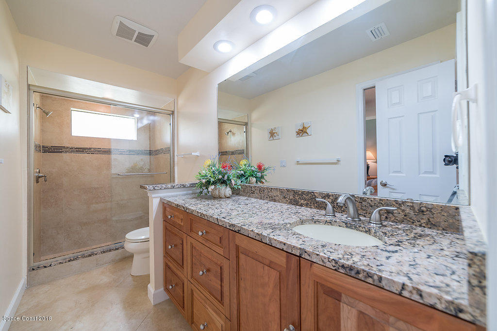 1401 Meadowbrook Road Northeast Palm Bay, FL 32905 - Photo 10 of 46 a bathroom with a granite countertop sink toilet and shower