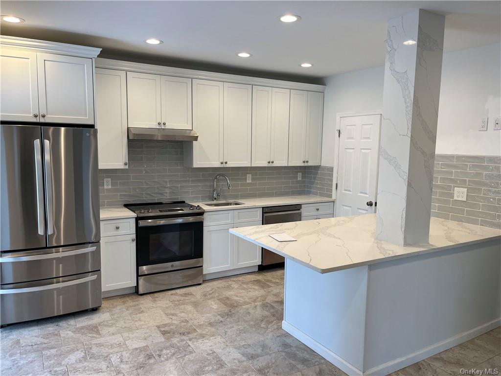a kitchen with kitchen island granite countertop stainless steel appliances and sink
