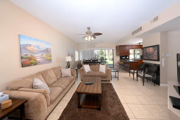 a living room with furniture a chandelier and a dining table