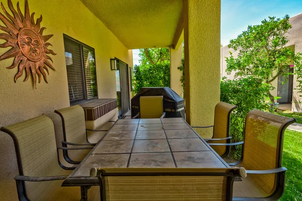 a balcony with table and chairs